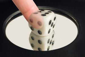 Example of the illusion.  A seemingly solid die is passed through by a finger. 