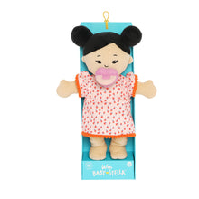 Load image into Gallery viewer, Wee Baby Stella Light Beige with Black Buns in packaging.  She is wearing an orange dress with oranges on it and a purple pacifier is in her mouth.  
