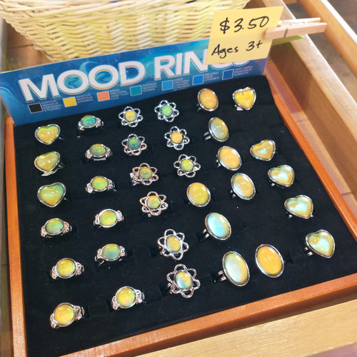 Mood ring display featuring various shapes of insets including hearts, an oval, a flower, and a circular gem.  