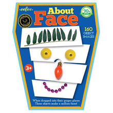 Load image into Gallery viewer, About face packaging; A blue box with an example of the faces one could  create. This one features a head of leaves for hair, olive eyes, a single lightbulb nose and a string of beads as a purple smile!
